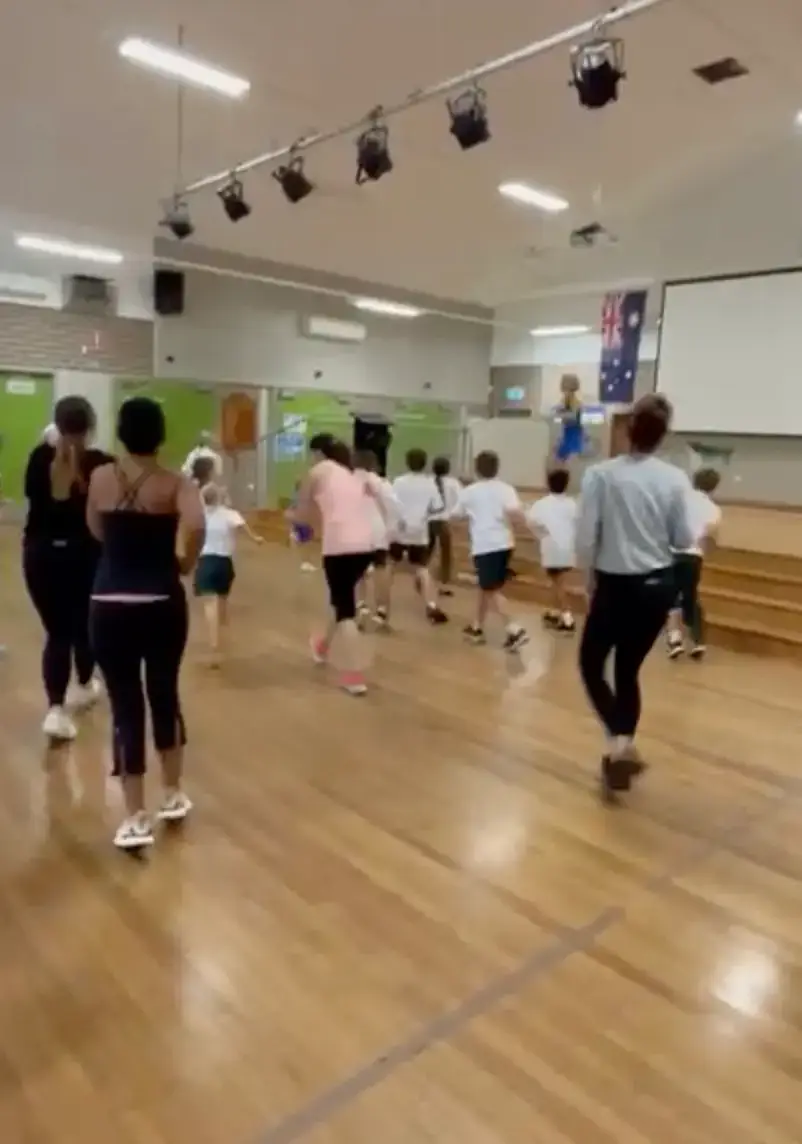 Mums and kids dancing together at a school event