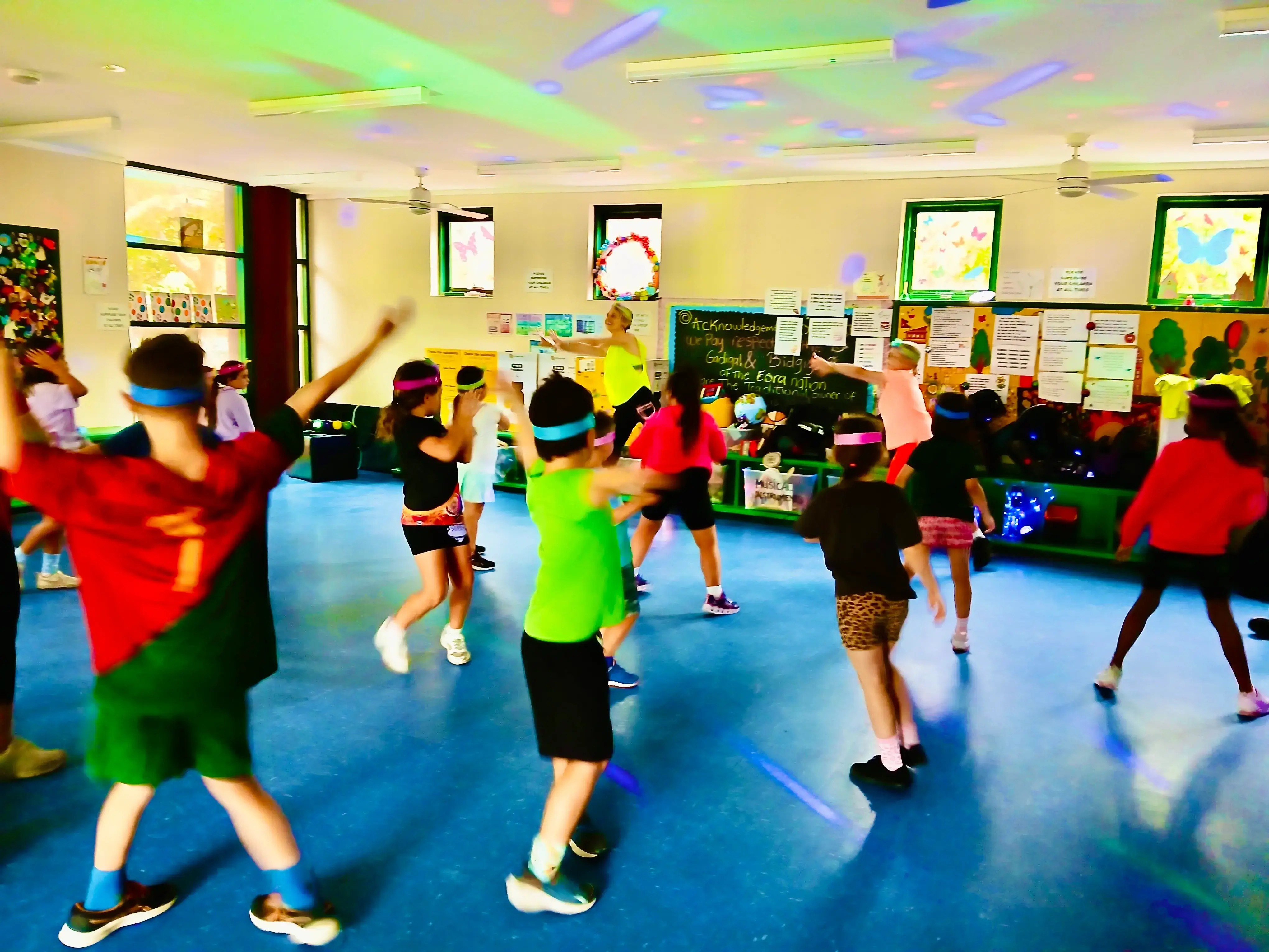 A full hall of children mid-routine at a vacation care dance party